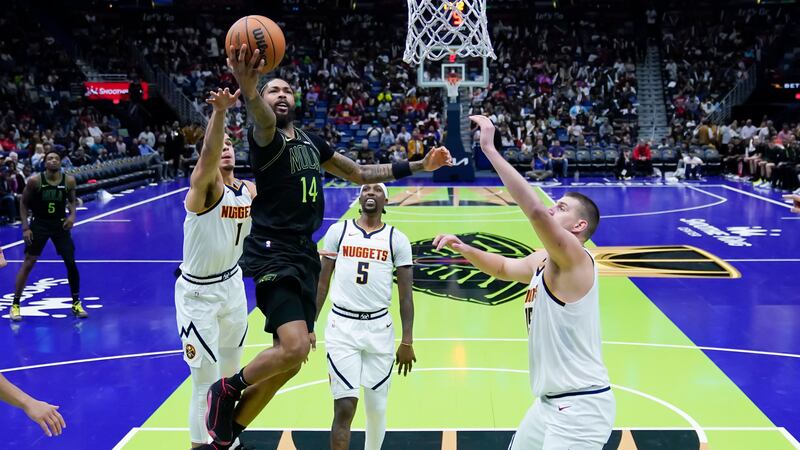 New Orleans Pelicans forward Brandon Ingram (14) drives to the basket between Denver Nuggets...