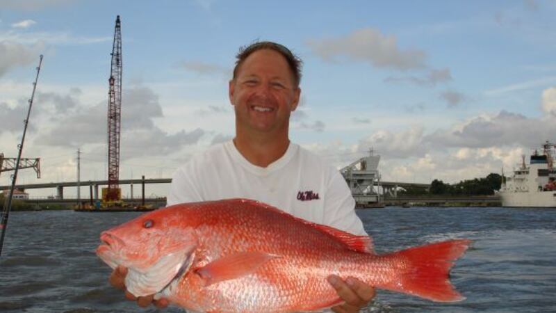 Former Ole Miss football coach Mike Markuson shows off a red snapper he caught last year on...