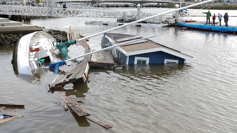 A boat and houseboat float submerged at Jack London Aquatic Center after the boat from a...