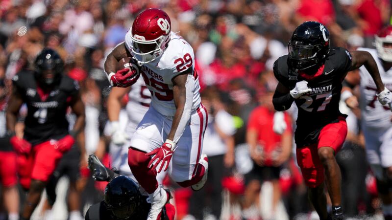 Oklahoma running back Tawee Walker (29) carries the ball as he breaks a tackle against...