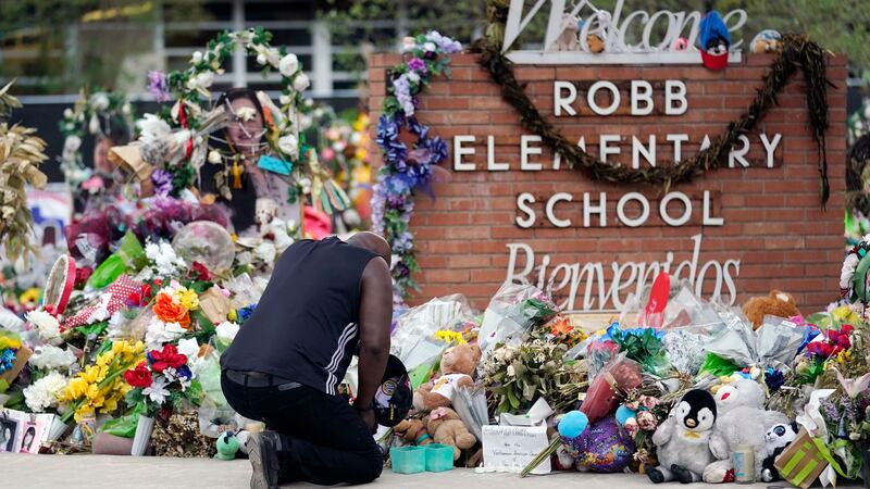 FILE - Reggie Daniels pays his respects at a memorial at Robb Elementary School, June 9, 2022,...